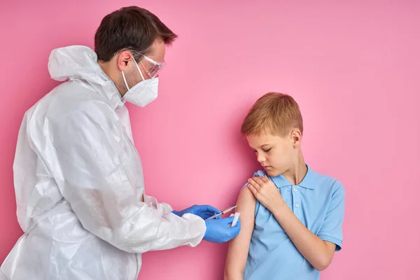 Man läkare som håller i en spruta med nål och ger en vaccination i patientarmen — Stockfoto