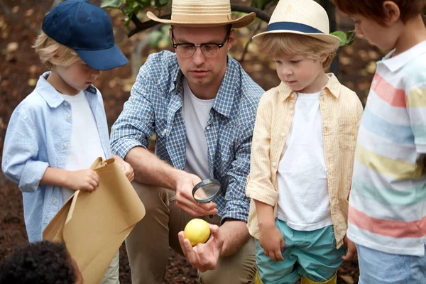 Der Wanderführer hält einen Einführungsvortrag für Kinder im Garten — Stockfoto