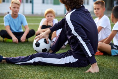 Kendine güvenen futbol antrenörü çocuklara öğretir, öğretir.
