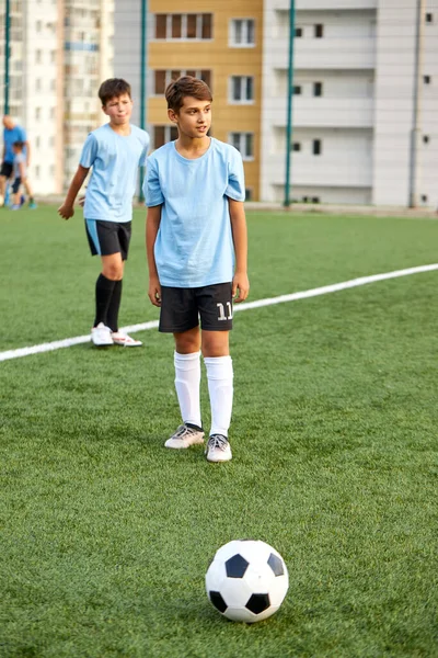 Спортивный мальчик пинает мяч, пенальти — стоковое фото