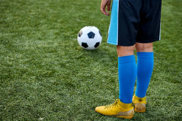 Niño niño pateando pelota de fútbol en el campo de deportes —  Fotos de Stock