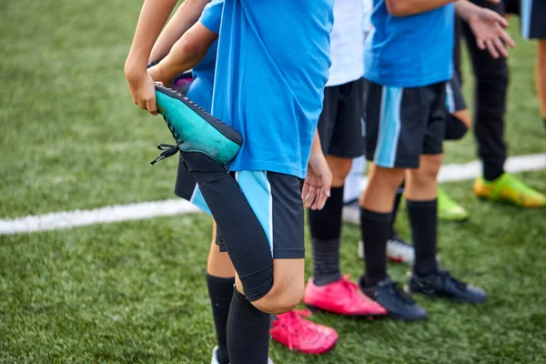 Grupo de niños caucásicos que estiran las piernas antes del partido de fútbol —  Fotos de Stock