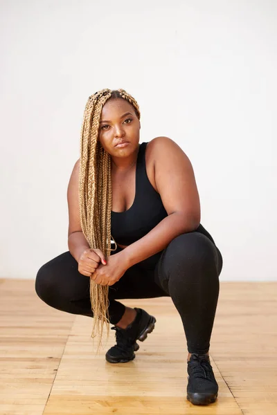plump, plus size african american woman in sportswear posing in studio