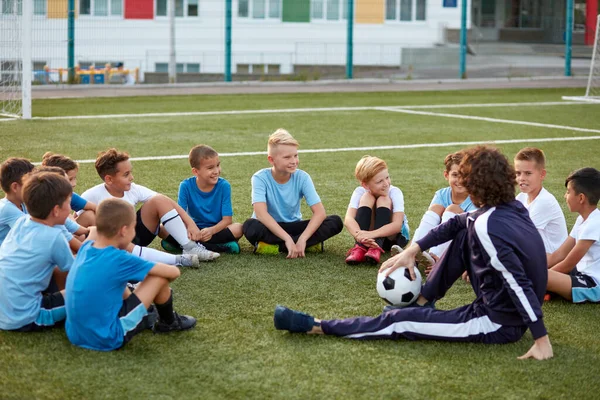 스포츠를 즐기는 소년들로 구성 된 젊은 팀이 축구 시합중에 휴식을 취한다 — 스톡 사진