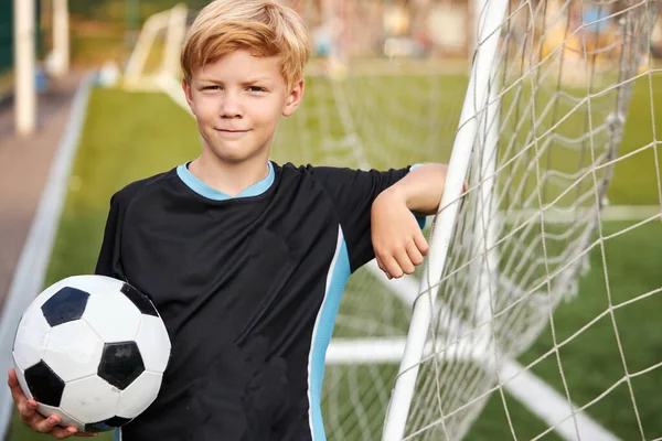 Portret van lachende blanke jongen met voetbal bal in handen — Stockfoto