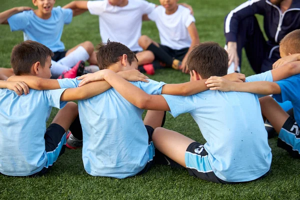 Φιλικό παιδιά αγόρια έχουν ξεκουραστεί με εκπαιδευτή κατά τη διάρκεια του ποδοσφαιρικού διαγωνισμού — Φωτογραφία Αρχείου