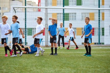 Bir grup sportif sporcu çocuk futbol oynuyor.