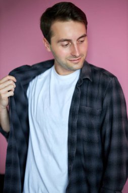 Utangaç erkek kareli gömleğini çıkartıyor.