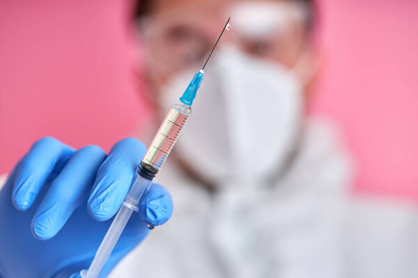 крупным планом врач или медсестра рука с нитриловой перчаткой держит грипп, вакцину от кори