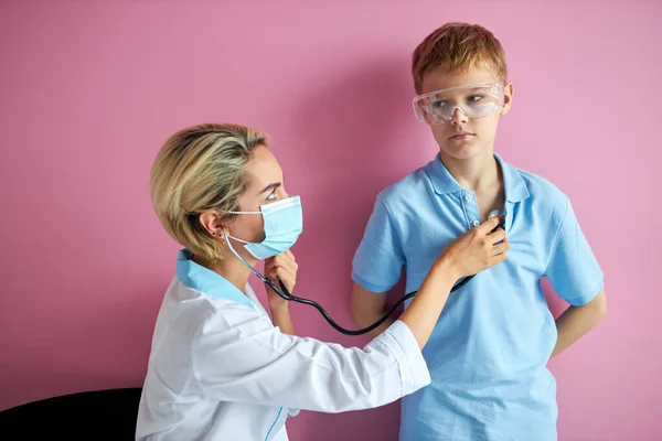 Női orvos használja sztetoszkóppal, hogy ellenőrizze a szívverés hangját kisfiú — Stock Fotó