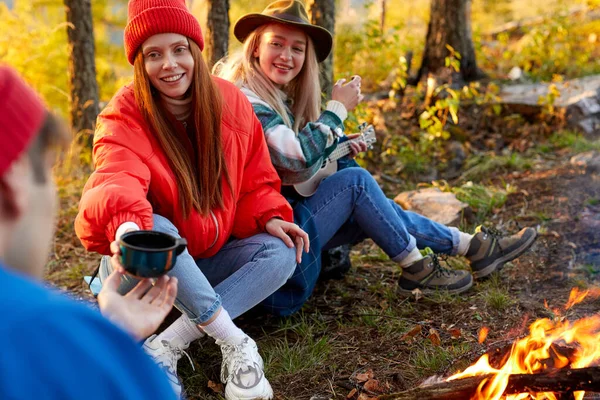 Giovani amici rilassarsi comodamente e bere tè caldo in una serata d'autunno all'aria aperta — Foto Stock