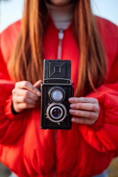 Woman holding retro camera in hands, focus on camera — Stock Photo, Image