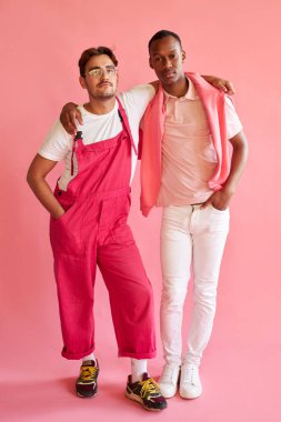 Pembe elbiseli iki yakışıklı adam yalnız poz veriyor.