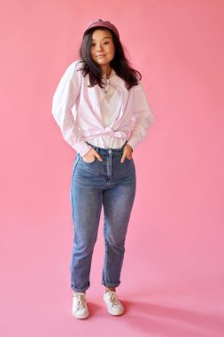 Stüdyoda poz veren günlük giysili çekici Asyalı kadın.