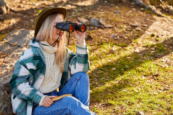 Mujer senderismo utilizar binoculares durante el viaje, turista mirando a través de binoculares — Foto de Stock