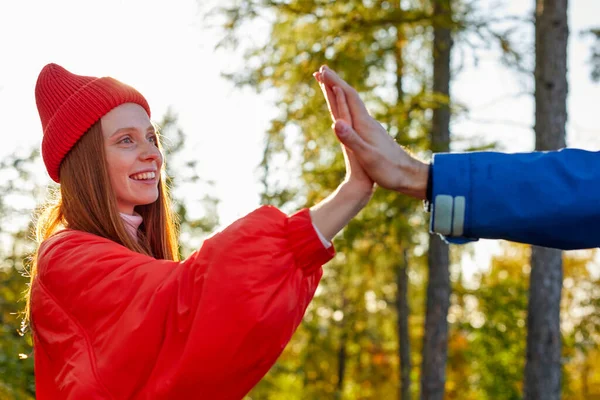 Sude pohled na šťastný ryšavý žena je dávat high five na přítele — Stock fotografie