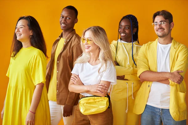 Farklı kültürlerden gelen bir grup arkadaş sarı arka planda izole edilmiş. — Stok fotoğraf