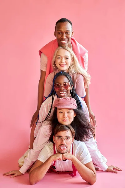 Lustig diverse Menschen in einer Reihe isoliert über rosa Hintergrund — Stockfoto