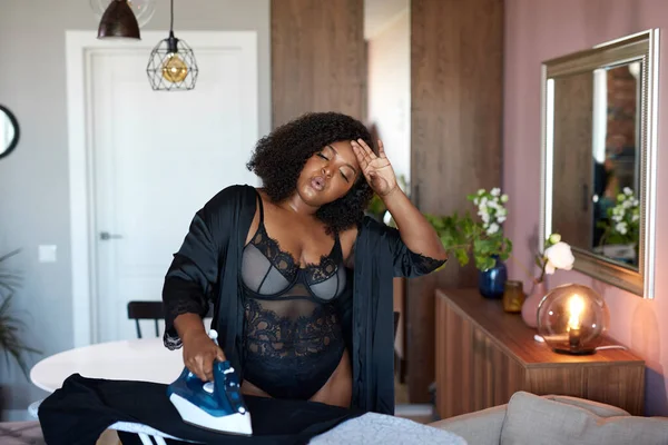 Negro africano más tamaño mujer cansado o planchar ropa —  Fotos de Stock