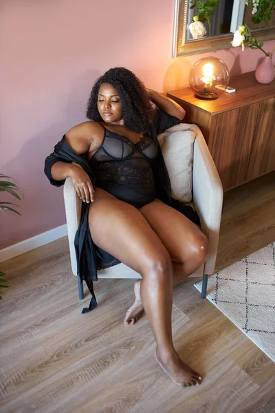 Goed uitziende Afrikaanse vrouw met half naakt plus size lichaam zit op fauteuil — Stockfoto