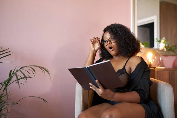 Wanita kulit hitam yang kelebihan berat badan membaca buku di rumah — Stok Foto