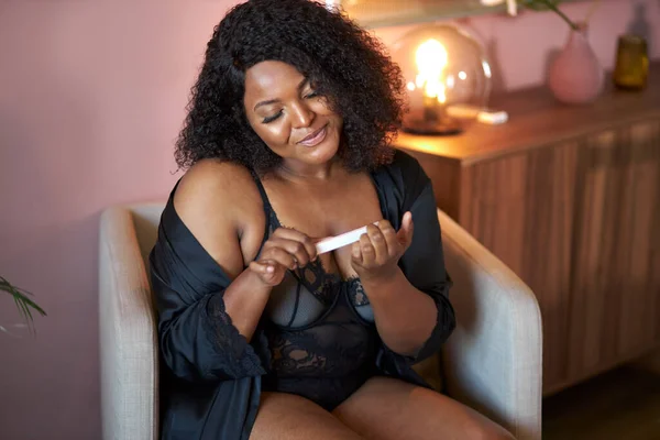Young african woman saws her nails with nail file — Stock Image Young african woman saws her nails with nail file Royalty Free Stock Photos