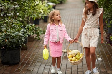Sepet dolusu limonu olan iki farklı kız çocuğu.