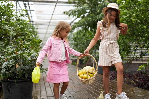 two diverse kid girls with basket full of lemons