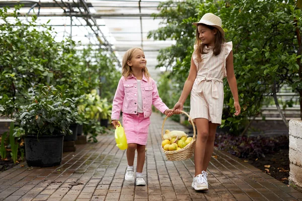 two diverse kid girls with basket full of lemons