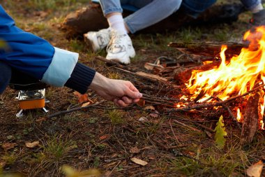 Yolculuk sırasında erkek ellerinin ateş yakmaya çalıştığı yakın plan fotoğraf, macera.