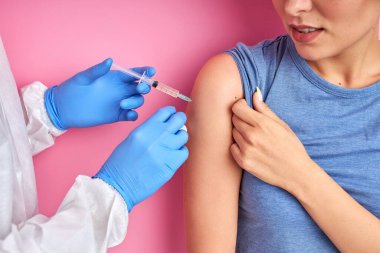 Şırıngalı kendine güvenen bir doktor aşı, grip, kadının omzunda grip...