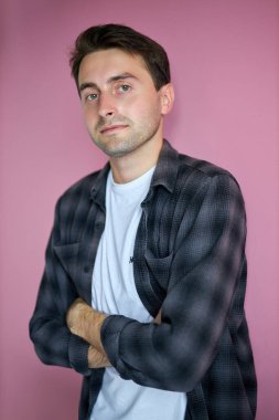 Kameraya yalnız poz veren günlük gömlekli yakışıklı beyaz adam.