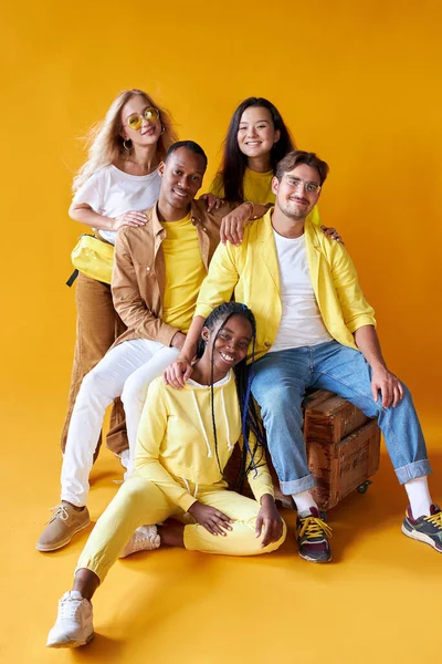 Estudantes de diferentes países em estúdio com fundo amarelo — Fotografia de Stock