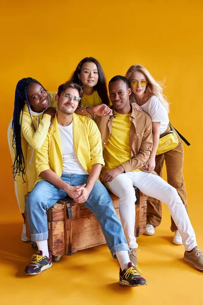 Estudiantes de diferentes países en estudio con fondo amarillo — Foto de Stock