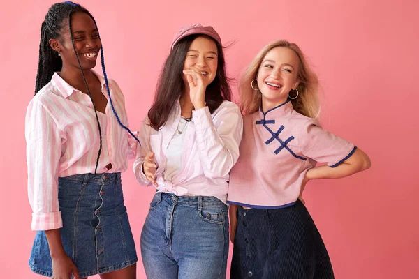 Trois belles jeunes amies diverses posant avec sourire et s'amuser sur fond rose — Photo