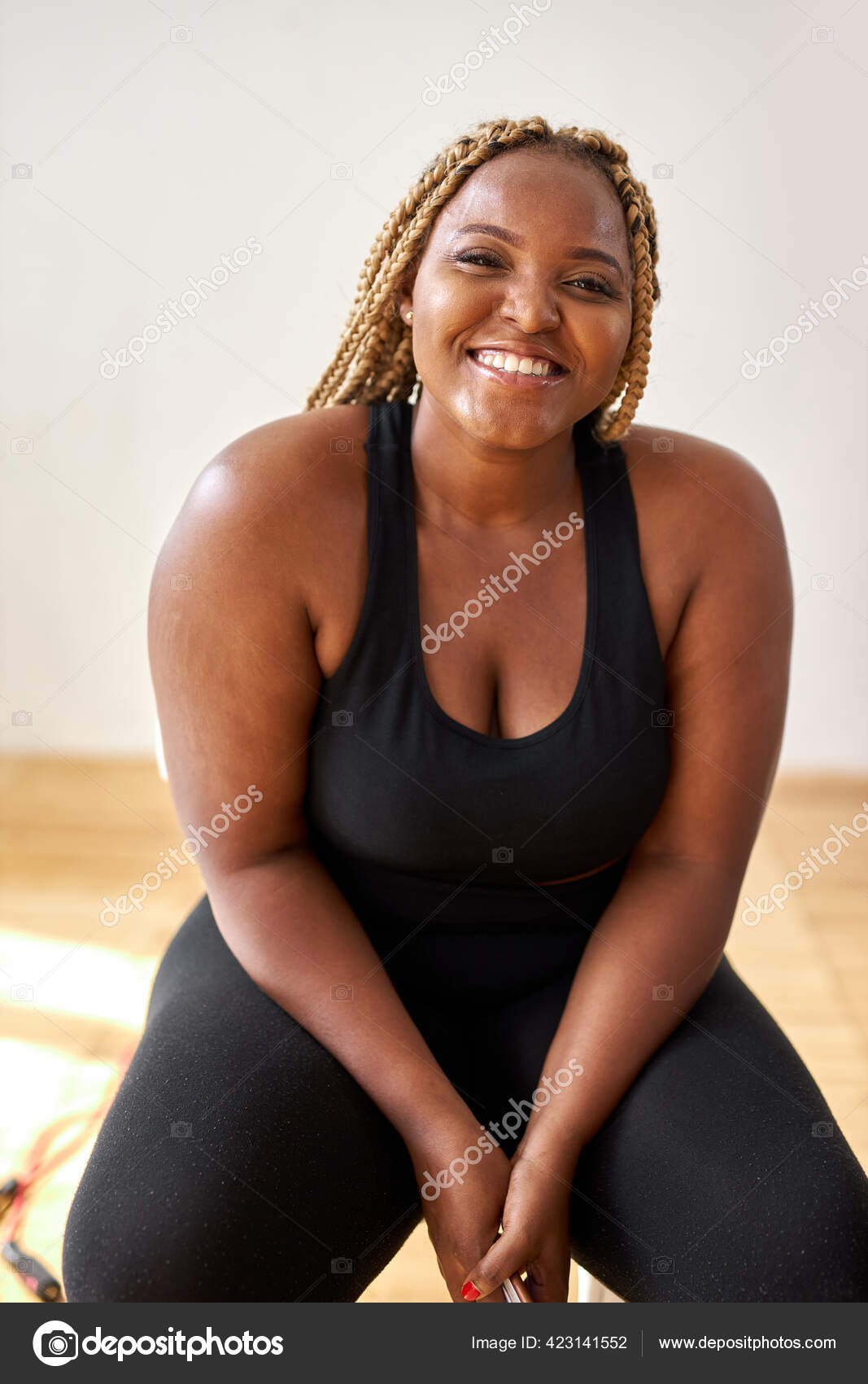 Regordeta, además de tamaño afroamericano mujer en ropa deportiva sentarse mirando a la cámara: fotografía stock © romanchazov27 #423141552 Depositphotos