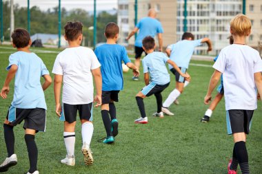 Stadyumdaki genç futbol takımları arasında antrenman ve futbol maçı