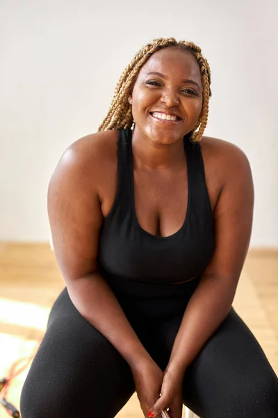 Plump, plus size african american woman in sportswear sit looking at camera  Stock Photo by ©romanchazov27 423141552