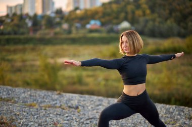 Çekici güçlü kadın dışarıda egzersiz yapıyor.