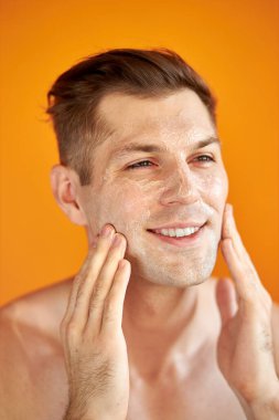 Beyaz tenli yakışıklı bir adam cildini önemser, nemlendirir.
