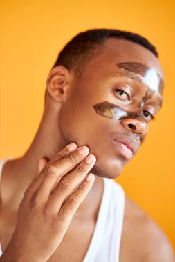 Yüzünde maske olan Afro-Amerikan genç adam.