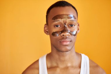 Yüzünde maske olan Afro-Amerikan genç adam.