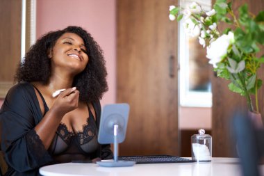 Güzel afro-amerikan siyah kadın evde makyaj yapıyor.