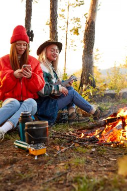 İki tatlı beyaz kadın tırmanıştan sonra dinlenerek şarkı söylüyor.