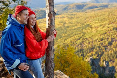Romantik fit çift, sonbahar dağlarını düşünerek ayağa kalkar.