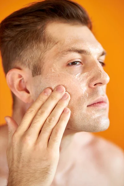 ヨーロッパの男は健康な肌を得るための顔を保湿 — ストック写真