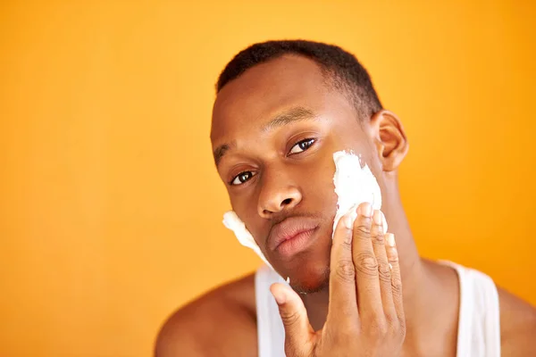 Negro africano hombre aplicar espuma afeitado después de ducha, hacer belleza piel procedimientos — Foto de Stock