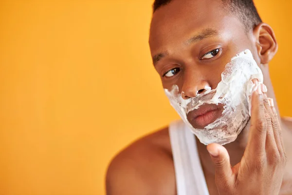 Siyah Afrikalı adam duştan sonra tıraş köpüğü sürer, güzellik ameliyatı yapar. — Stok fotoğraf