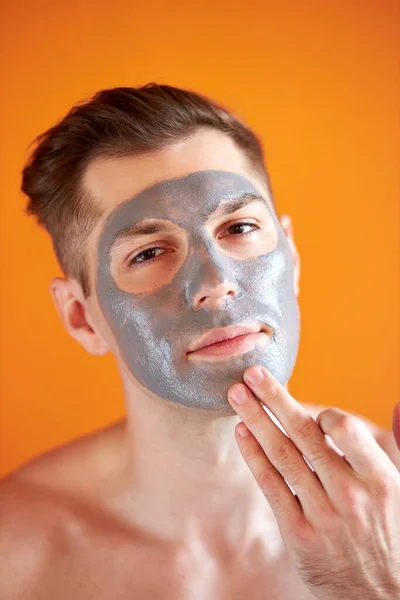 Joven guapo recibiendo tratamientos de spa, posando ante la cámara sobre un fondo amarillo aislado — Foto de Stock