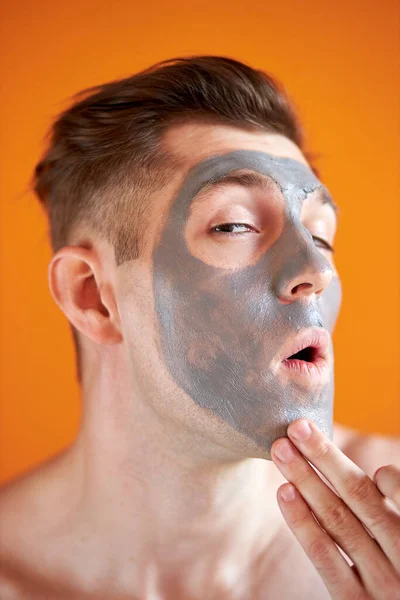 Joven guapo recibiendo tratamientos de spa, posando ante la cámara sobre un fondo amarillo aislado —  Fotos de Stock